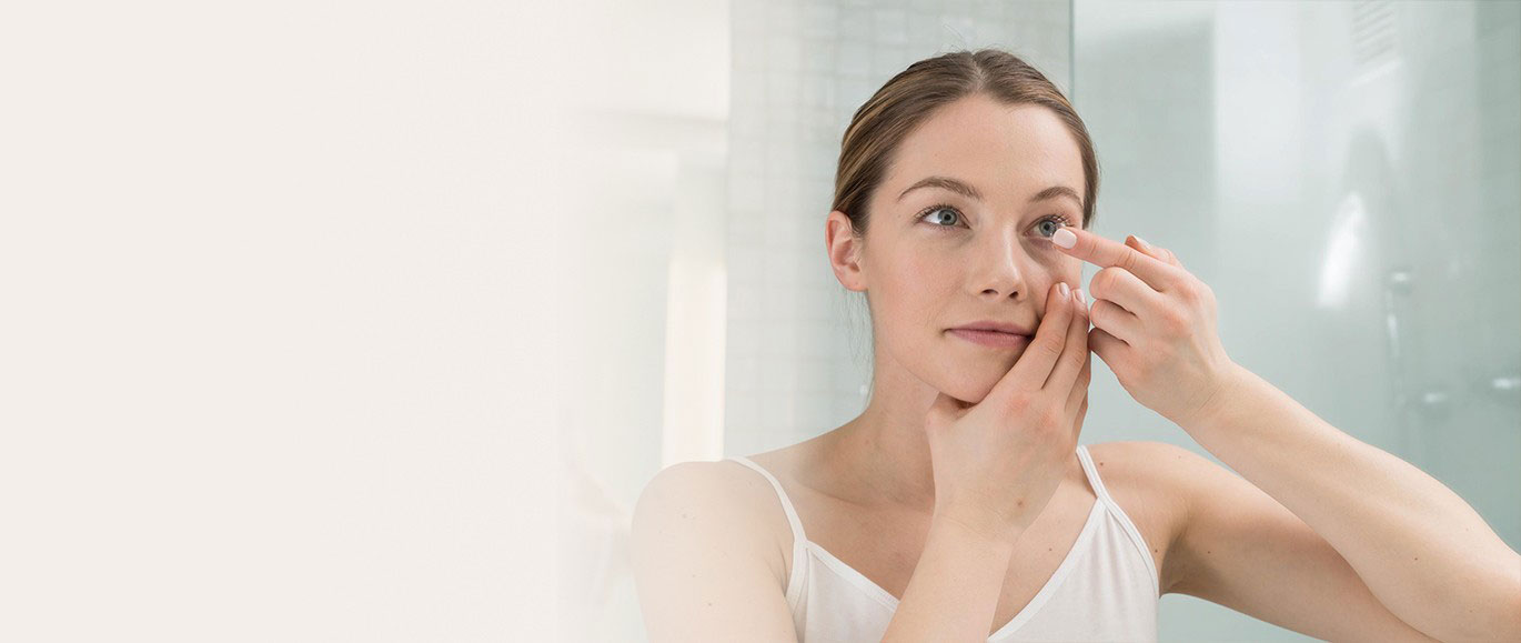 Woman putting on contact lenses