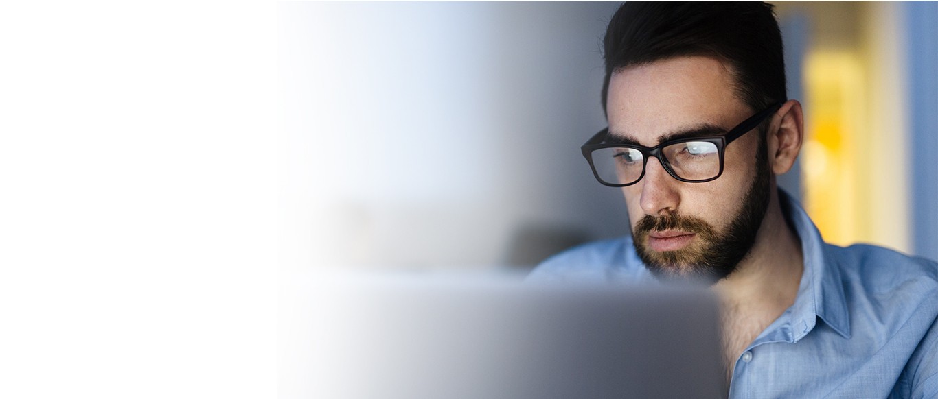 Man at screen wearing blue light glasses prescribed to him by Bristol